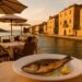 waterfront restaurant terrace in Vis, Croatia at golden hour, with fresh grilled fish